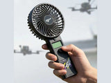 Hand holding Flywoo QuickCool VTX fan for drone cooling outdoors
