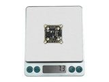Sequre H743 V2 flight controller weighing 7.3 grams on digital scale